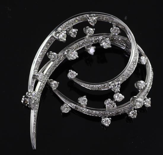 A modern 18ct white gold and diamond set open scroll brooch, 1.75in.